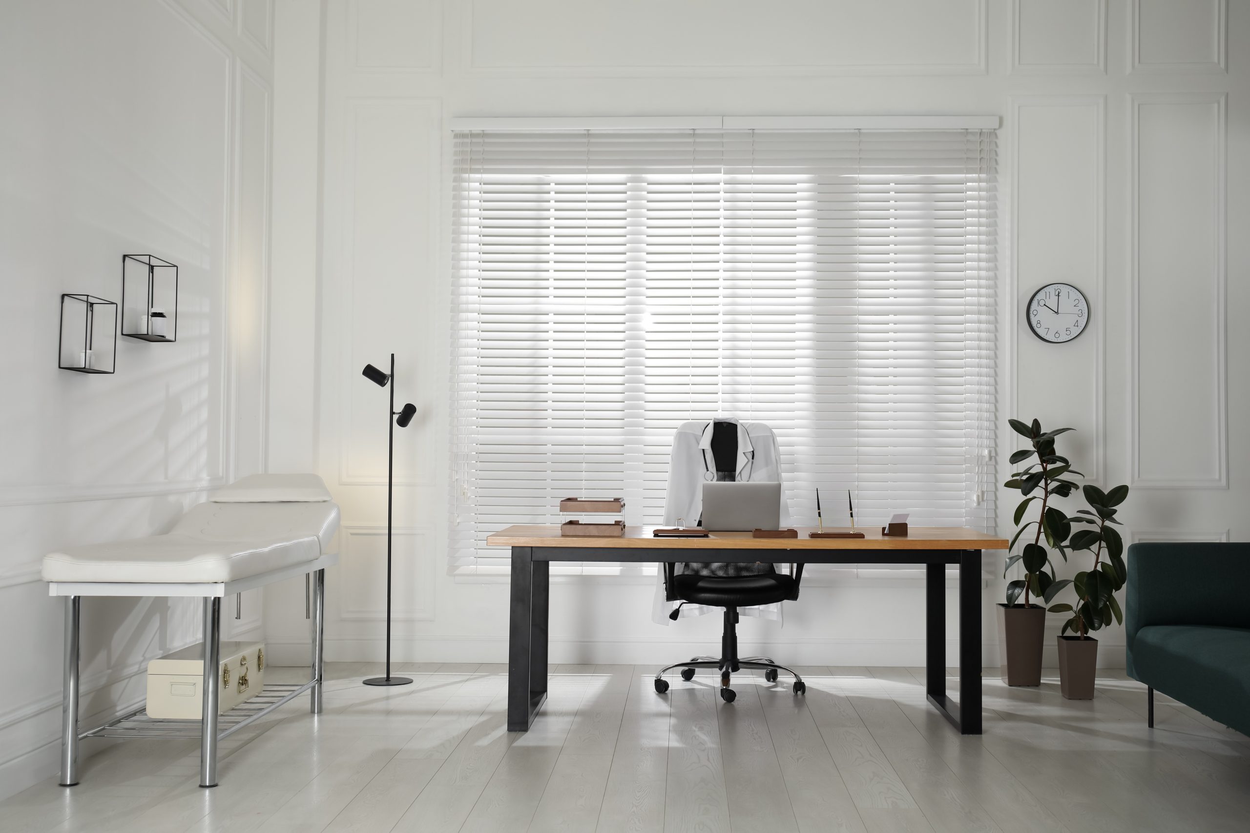 Modern medical office interior with doctor's workplace and examination table