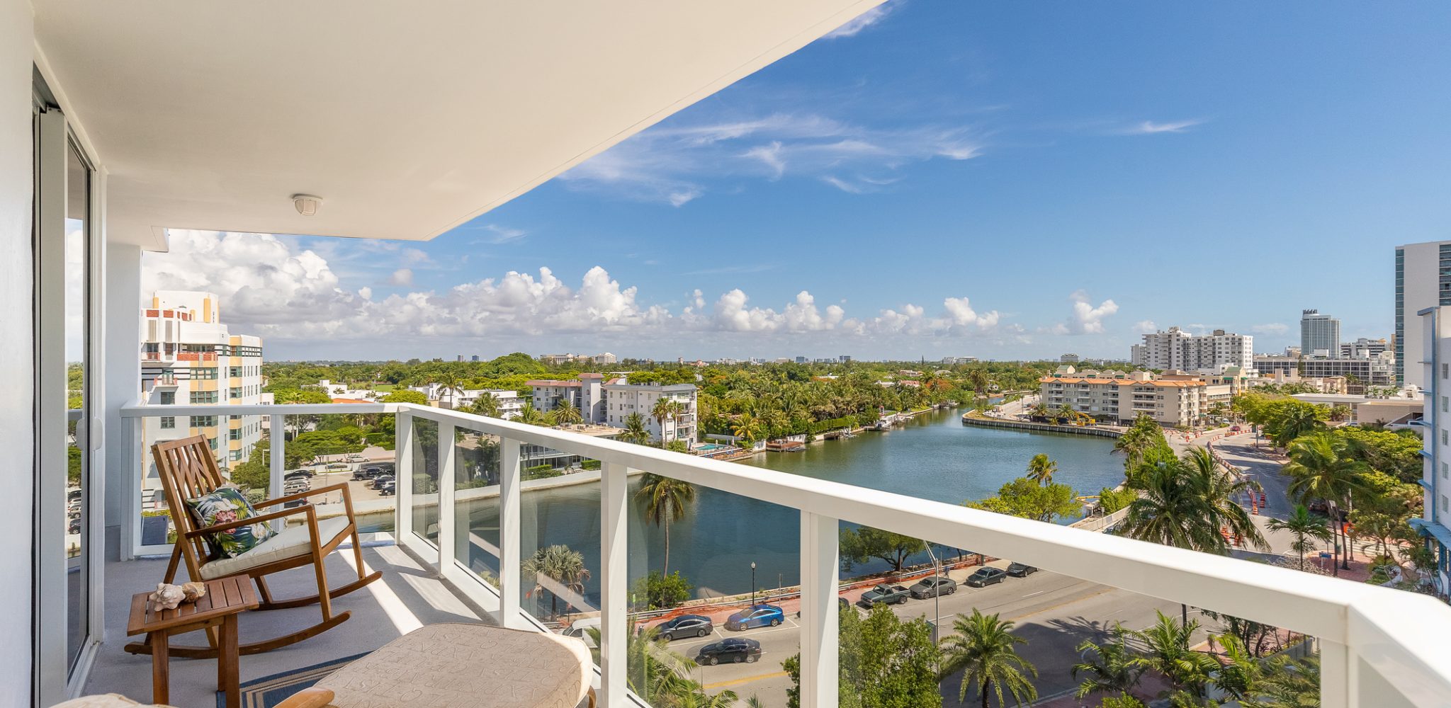 View of balcony in Mid-Beach in Miami Beach biscayne bay is observed, beach with the turquoise sea, modern buildings and towers, tropical and summer weather, blue sky with clouds